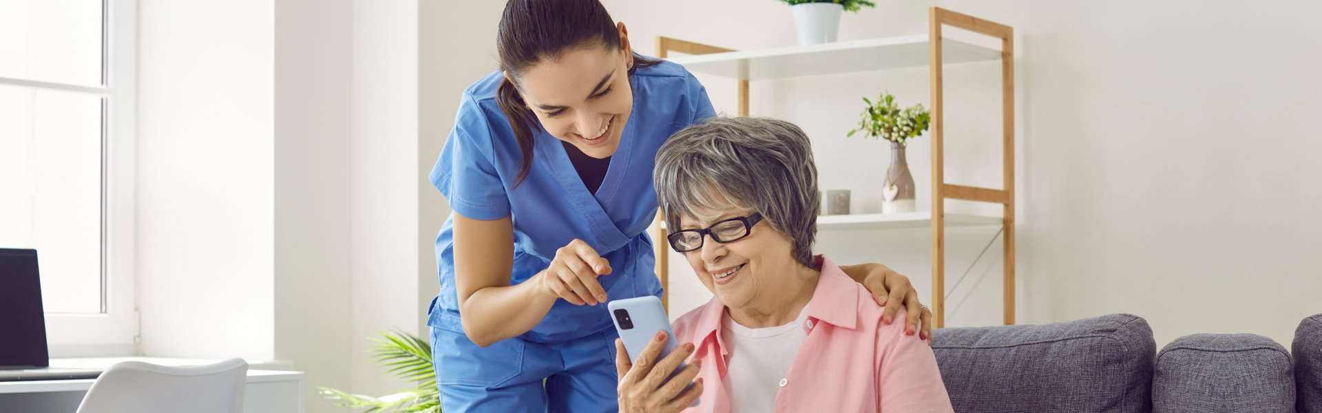 nurse teaching her patient how to use a smartphone