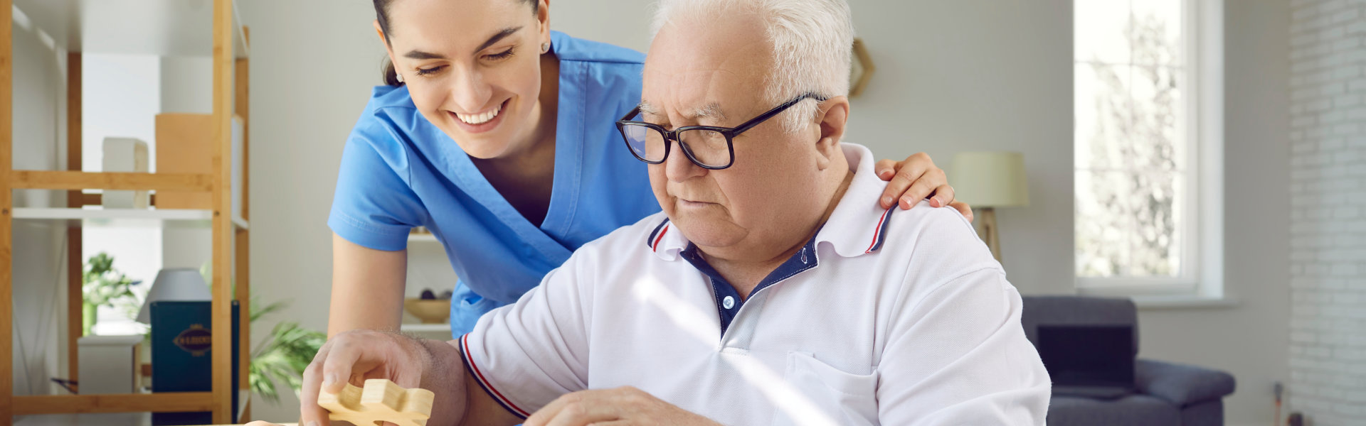 senior man doing puzzles with caregiver