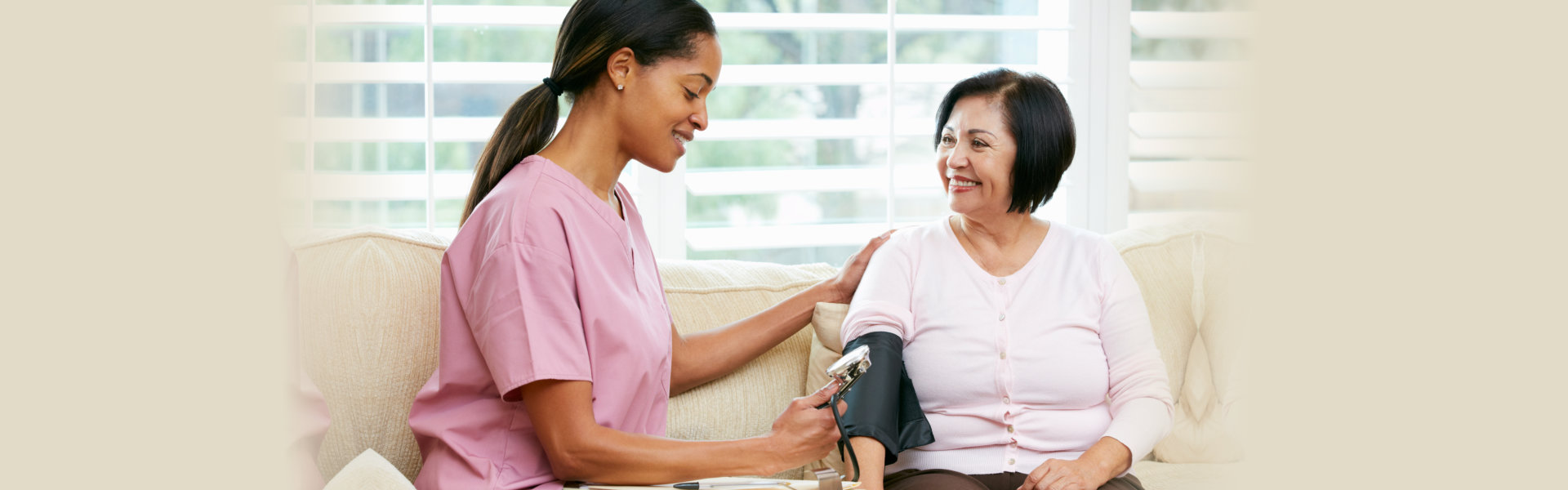 caregiver taking bloodpressure to an elderly